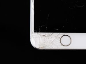 Närbild av en mobil med kraftigt sprucket och krossat skärmglas